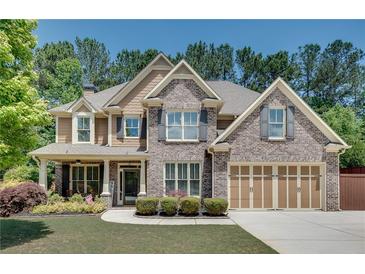 Beautiful brick-and-siding two-story home with a manicured lawn and a three-car garage at 204 Arthur Hills Dr, Acworth, GA 30101