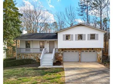 Charming two-story home featuring stone accents, a covered porch, and an attached two-car garage at 6974 Clearlake Ct, Peachtree Corners, GA 30360