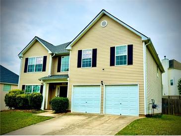 Inviting two-story home featuring a neat lawn, double garage, and a classic suburban design at 220 Baltimore Ave, Stockbridge, GA 30281