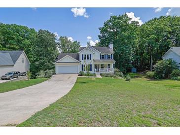 Charming two-story home with an attached garage, well-maintained lawn, and inviting curb appeal at 7155 Bannister Park Ln, Cumming, GA 30028