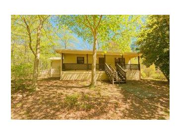 Charming single-story home featuring a welcoming front porch and lush, natural surroundings at 10213 Tall Pine Ct, Villa Rica, GA 30180