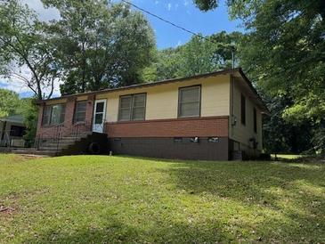 Traditional single-story home featuring mixed siding, brick details, and mature trees at 3127 Latona Sw Dr, Atlanta, GA 30354