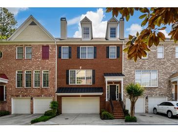 Charming brick townhome with a two-car garage and a well-manicured front yard at 10090 Jones Bridge Rd # 2, Alpharetta, GA 30022