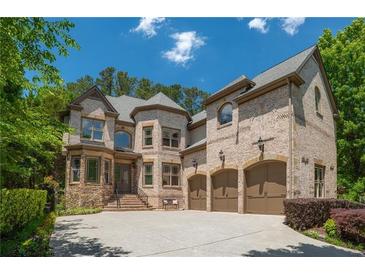 Stunning brick home featuring a three car garage and well-manicured landscaping at 3680 Milton Park Dr, Alpharetta, GA 30022