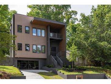 Modern home featuring a unique facade, multiple levels, and a well-manicured lawn with mature trees at 187 Clay Se St, Atlanta, GA 30317