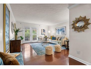Bright living room features hardwood floors and French doors to the balcony at 3701 Essex Ave # 2, Atlanta, GA 30339