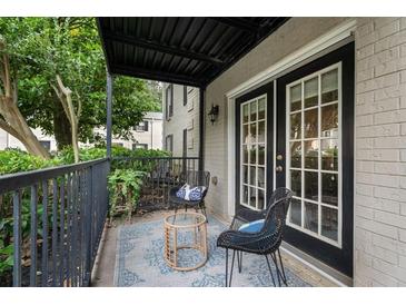Cozy covered patio with black metal furniture and a textured rug, perfect for relaxing outdoors at 3701 Essex Ave # 2, Atlanta, GA 30339