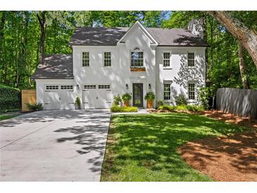 Stunning two-story home with a manicured lawn, attached garage, and classic white painted brick exterior at 4331 Volnay Ne Ct, Marietta, GA 30066