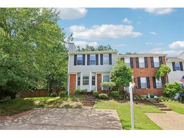 Charming two-story townhouse featuring a bay window, brick accents, and a well-manicured front yard at 1712 Grist Mill Dr, Marietta, GA 30062