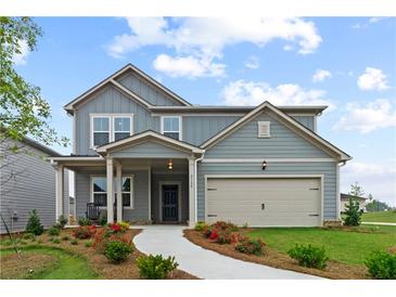 Charming two-story home featuring a welcoming front porch and well-manicured landscaping at 2010 Moonlight Path, Covington, GA 30016