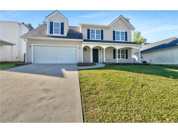 Charming two-story home with a well-manicured lawn, a two-car garage, and a welcoming front porch at 3479 Woodruff Ridge Ln, Loganville, GA 30052