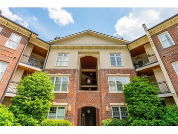 Elegant brick condominium exterior featuring balconies and manicured landscaping at 825 Highland Ne Ln # 1116, Atlanta, GA 30306