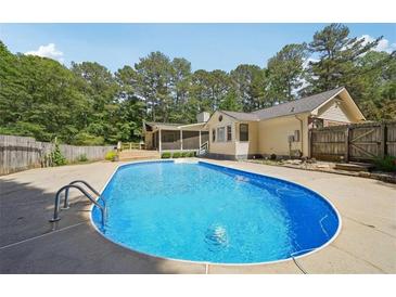 Backyard pool with concrete surround and mature trees providing ample shade and privacy at 19 Margrit Ct, Stockbridge, GA 30281