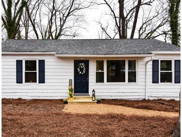 Charming single-story home featuring a navy door, a gray roof, and a well-kept front yard at 3601 Orchard Cir, Decatur, GA 30032