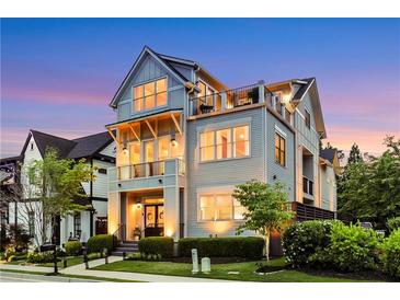 Inviting three-story home featuring dual balconies and rooftop deck, complemented by manicured landscaping at 4550 Lois Se St, Smyrna, GA 30080