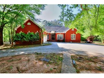 Charming red brick home with lush green trees surrounding the property at 5618 Highway 212, Covington, GA 30016