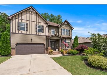 Charming two-story home featuring manicured lawn, two-car garage, and decorative shutters, complete with beautiful landscaping at 1645 Horseshoe Creek Ln, Cumming, GA 30041