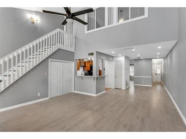 Bright living room boasts hardwood floors, a staircase, and neutral paint, with a glimpse of the kitchen area at 4234 Stillwater Dr, Duluth, GA 30096