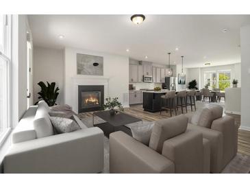 Open-concept living room with fireplace that flows into the modern kitchen and dining area at 387 Skylar Se Way, Atlanta, GA 30315