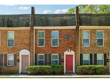 Charming townhome featuring a brick facade, trimmed windows, and a well-maintained front garden at 135 N North River Dr, Atlanta, GA 30350