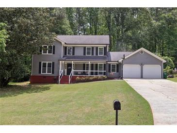 Charming two-story home with gray siding, black shutters, and a welcoming front porch at 4261 Vineyard Trl, Snellville, GA 30039