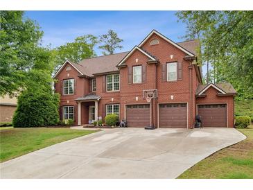 Impressive brick home with a three-car garage and well-manicured lawn in a desirable neighborhood at 4960 Tadmore Ln, Lithonia, GA 30038