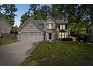 Charming two-story home with a well-maintained lawn and attached two-car garage at 5320 Taylor Rd, Alpharetta, GA 30022