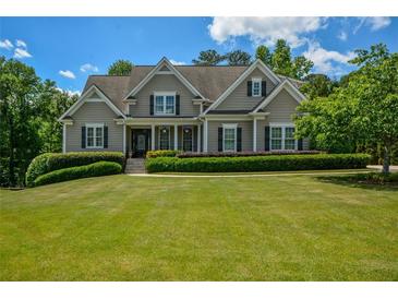 Charming home featuring manicured lawn, beautiful landscaping, and classic architectural details for a stunning curb appeal at 3740 Duckcove Way, Cumming, GA 30041