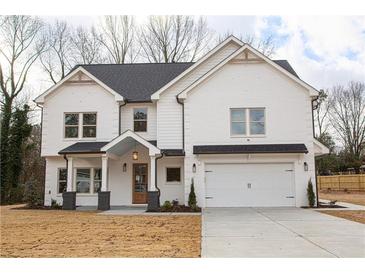 Beautiful two-story white brick home with a covered porch and a two-car garage on a large lot at 3774 Eli Dr, Snellville, GA 30039