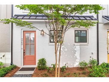 Charming townhome featuring a peach-colored front door, black trim, and freshly landscaped yard at 4462 Dandelion Ln, Atlanta, GA 30342