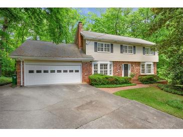 Charming two-story home with a brick and light yellow facade, attached garage, and a well-maintained lawn at 3999 Saint Clair Ne Ct, Brookhaven, GA 30319