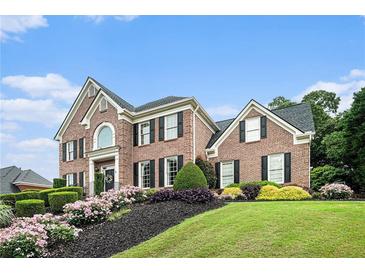 Beautiful brick home with manicured lawn and colorful landscaping at 2258 Bright Water Dr, Snellville, GA 30078