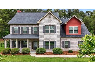 Charming two-story home featuring a brick facade, complemented by a well-maintained lawn and mature landscaping at 117 Constance Dr, Locust Grove, GA 30248