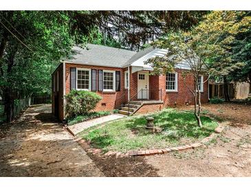 Charming brick home featuring black shutters, a landscaped yard, and a paved walkway at 1986 N Decatur Ne Rd, Atlanta, GA 30307