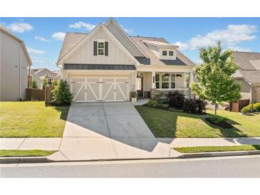Charming two-story home boasts a manicured lawn and a welcoming front porch at 410 Gardens Of Harmony Dr, Canton, GA 30115