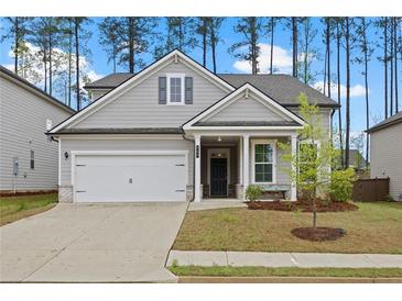 Charming single-Gathering home featuring a gray siding, well-manicured lawn, and a two-car garage at 730 Lanarck Way, Peachtree City, GA 30269