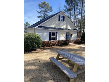 Exterior view of the community pool house and picnic benches on a sunny day at 748 Great Oak Pl, Villa Rica, GA 30180