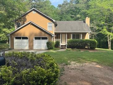 Charming two-story home featuring an attached two-car garage and a well-maintained lawn at 4896 Muirwood Dr, Powder Springs, GA 30127