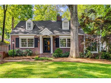 Charming brick home featuring black shutters, dormers, and mature landscaping at 277 Alberta Ne Dr, Atlanta, GA 30305