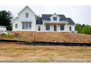 New construction modern farmhouse-style home with a black roof and white siding on a hilltop lot at 933 Mount Carmel Church Ln, Canton, GA 30114