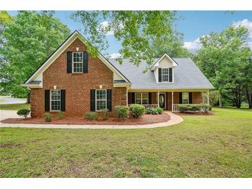Charming brick home with a manicured lawn and inviting front porch, perfect for relaxing and enjoying the neighborhood at 10 Hollow Ct, Covington, GA 30016