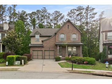 Charming brick home featuring a well-manicured lawn, attached two-car garage, and inviting covered front porch at 436 Barnett St, Woodstock, GA 30188