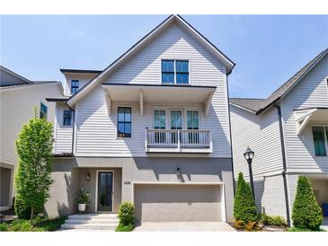 Charming two-story home featuring a balcony, an attached garage, and manicured landscaping at 4046 Hazel Nut Ln, Atlanta, GA 30342