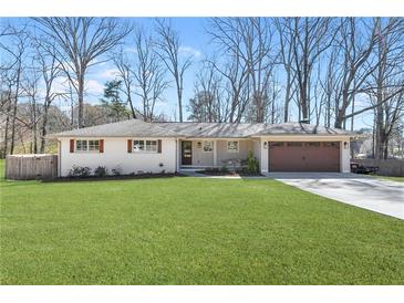 Charming, renovated single-story home featuring a lush green lawn, attached garage, and a welcoming front entrance at 4304 Lake Laurel Se Dr, Smyrna, GA 30082