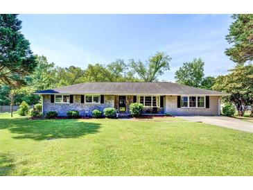 Charming ranch-style home with a well-manicured lawn, featuring a classic brick facade and mature landscaping at 5327 David Cir, Covington, GA 30014
