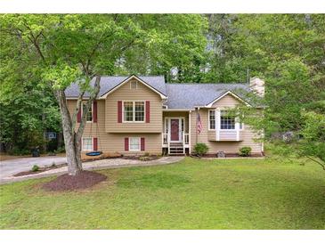 Charming two-story home with a well-maintained lawn, a tree swing, and red window shutters at 685 Maplelake Dr, Acworth, GA 30101