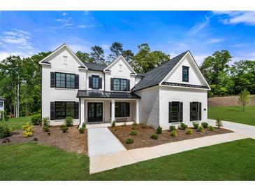 Stunning two-story white brick home featuring black window shutters and a beautifully landscaped front yard at 17145 River Overlook Dr, Roswell, GA 30075