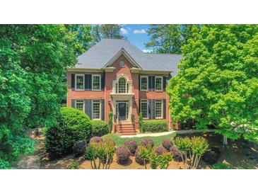 Beautiful two-story brick home with manicured landscaping, symmetrical design, and a welcoming front entrance at 6030 Sweet Creek Rd, Duluth, GA 30097