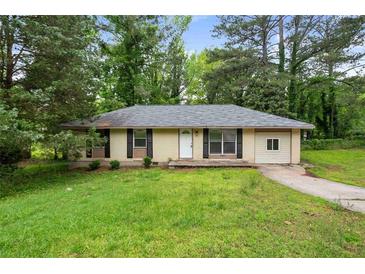 Charming single-story home with black shutters and well-maintained front yard and mature trees at 8169 Kendrick Rd, Jonesboro, GA 30238
