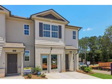 Charming townhome exterior with light-colored siding, brick accents, and well-maintained landscaping at 2366 Haran Dr # 37, Lithonia, GA 30058